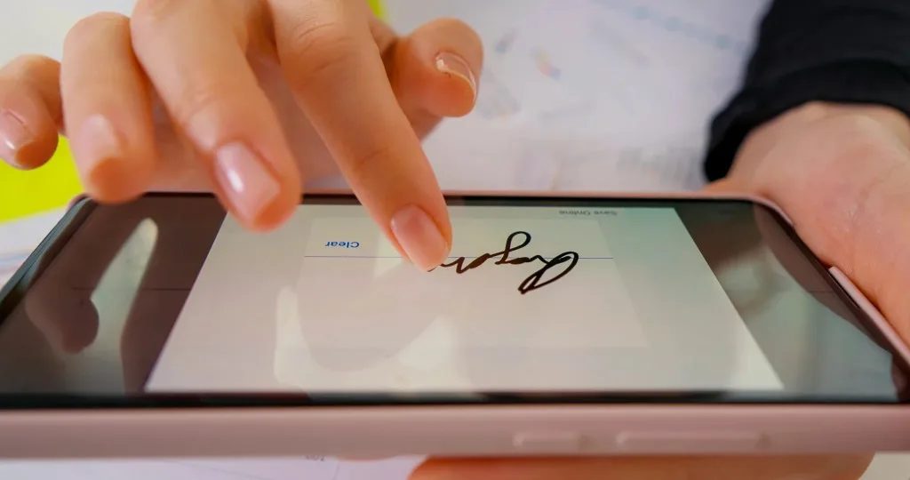 A customer signing a contract on a tablet screen