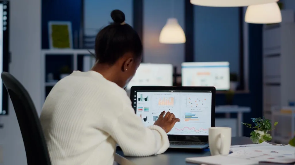 An analyst reviewing data dashboards on a laptop
