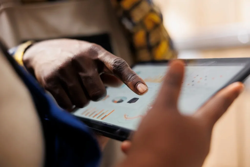 A person reviewing financial charts on a tablet
